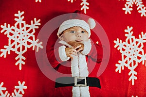 Christmas portrait of adorable newborn baby wearing Santa Claus` outfit