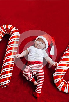 Christmas portrait of adorable newborn baby wearing Santa Claus` outfit. Top view