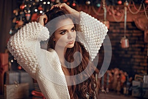 Christmas portrait of attractive woman with knitted sleeves. Beautiful brunette girl with long hair style wears in warm white woo