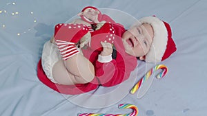 Christmas portrait of cute crying little newborn baby girl, wearing santa hat.
