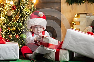 Christmas portrait of cute little baby in santa hat. Surprised kids face. Funny child New Year.