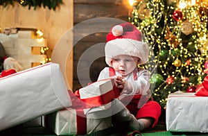 Christmas portrait of cute little baby in santa hat. Surprised kids face. Funny child New Year.