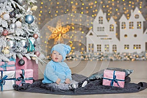 Christmas portrait of cute little newborn baby boy, dressed in christmas clothes and wearing santa hat, studio shot, winter time