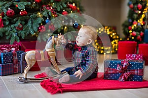 Christmas portrait of cute little newborn baby boy, dressed in christmas clothes and wearing santa hat, studio shot, winter time