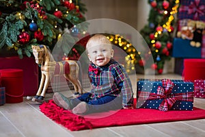 Christmas portrait of cute little newborn baby boy, dressed in christmas clothes and wearing santa hat, studio shot, winter time