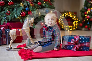 Christmas portrait of cute little newborn baby boy, dressed in christmas clothes and wearing santa hat, studio shot, winter time