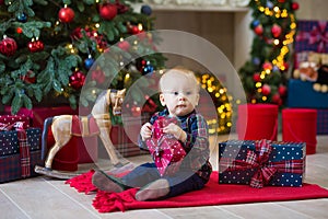 Christmas portrait of cute little newborn baby boy, dressed in christmas clothes and wearing santa hat, studio shot, winter time