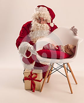 Christmas portrait of cute little newborn baby girl, dressed in christmas clothes, studio shot, winter time