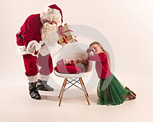 Christmas portrait of cute little newborn baby girl, dressed in christmas clothes, studio shot, winter time