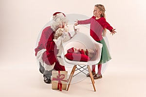 Christmas portrait of cute little newborn baby girl, dressed in christmas clothes, studio shot, winter time