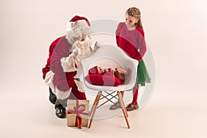 Christmas portrait of cute little newborn baby girl, dressed in christmas clothes, studio shot, winter time