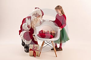 Christmas portrait of cute little newborn baby girl, dressed in christmas clothes, studio shot, winter time