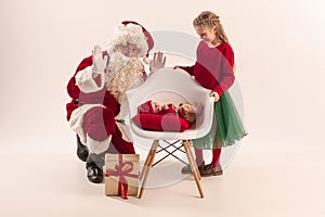 Christmas portrait of cute little newborn baby girl, dressed in christmas clothes, studio shot, winter time