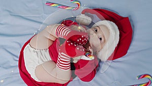 Christmas portrait of cute little newborn baby girl, wearing santa hat and dress, winter time.