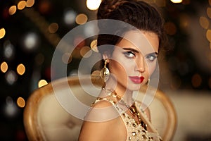 Christmas portrait of elegant woman with wedding hairstyle. Beauty makeup. Beuatiful brunette girl with golden jewelry in prom