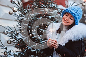 Christmas portrait of happy young woman walking in winter snowy city