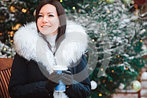 Christmas portrait of happy young woman walking in winter snowy city