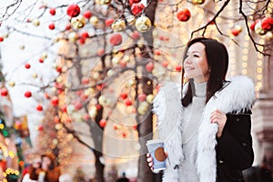 Christmas portrait of happy young woman walking in winter snowy city