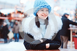 Christmas portrait of happy young woman walking in winter snowy city