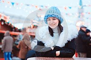 Christmas portrait of happy young woman walking in winter snowy city