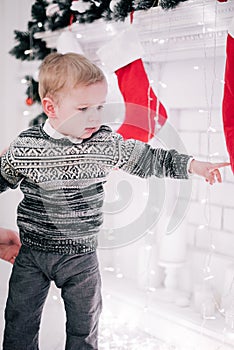 Christmas portrait of a young boy cozy atmosphere around the fireplace and Christmas tree