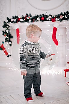 Christmas portrait of a young boy cozy atmosphere around the fireplace and Christmas tree