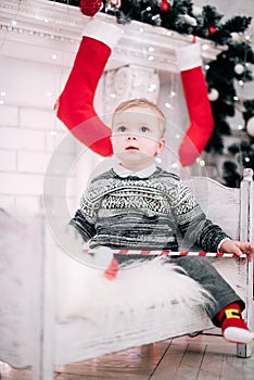 Christmas portrait of a young boy cozy atmosphere around the fireplace and Christmas tree