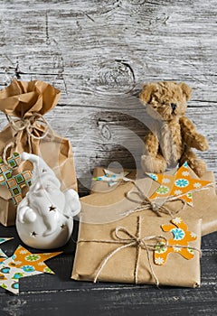 Christmas present, ceramic Santa Claus, toy bear on a wooden surface.