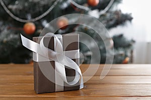 Christmas present on decorated tree background, holiday concept