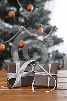 Christmas present on decorated tree background, holiday concept