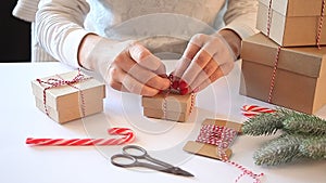 Christmas present decoration. Handmade decor concept. Woman wrapping gift box on the white table.