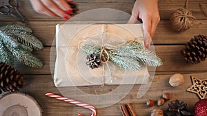 Christmas present decoration. Handmade decor concept. Woman wrapping gift box on the wooden table.