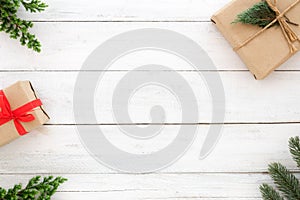 Christmas present gift boxes and fir leaves decoration rustic elements on white wood background