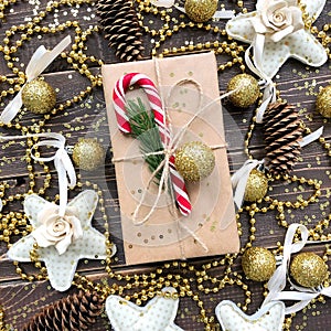 Christmas present on a wooden background with gold and candy