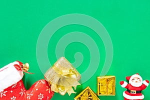 Christmas present gold gifts box and decorating elements on green background. Flat lay, top view and copy space composition with