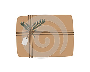 Christmas present in kraft paper with wisted rope and fir twig. Rustic gift box