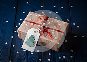 Christmas present with a red ribbon on a blue background with snowflakes