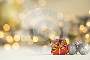 christmas present red and silver baubles against bokeh lights gold shiny glitter background with copy space