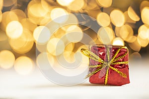 christmas present red and silver baubles against bokeh lights gold shiny glitter background with copy space