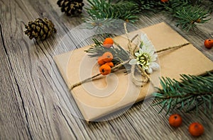 Christmas present wrapped in kraft paper with natural decoration. Angle view