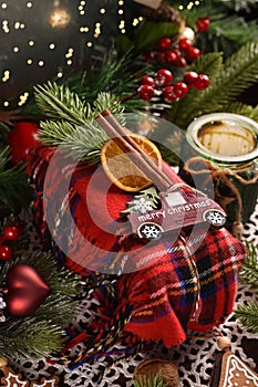 Christmas present wrapped in tartan scarf with decors as creative idea