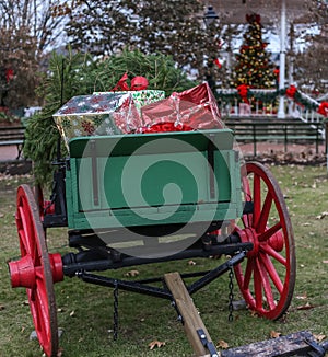 Christmas presents in antique wagon with blurred christmas tree in backround