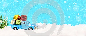 Christmas presents on blue truck riding through a snowy forest