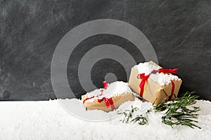 Christmas presents in snow against a blackboard