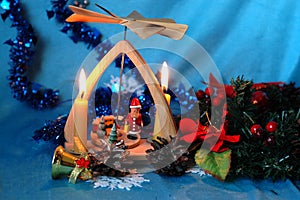 Christmas pyramid with candles, a wreath of fir branches and flo