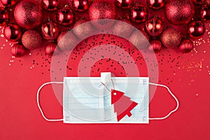 Christmas and quarantine concept. Top above overhead view close up photo of beautifully decorated red baubles confetti mask and