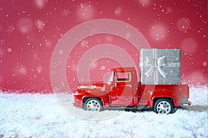 Christmas red background with snow and retro red car with gift box. .Merry Christmas and happy New Year greeting winter