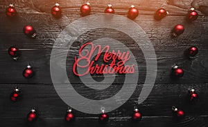 Christmas red bauble decorations on a black wooden background. Merry Christmas concept, top view