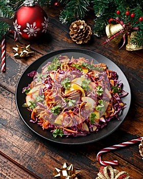 Christmas Red Cabbage, carrots, apples and pecan nuts Salad with decoration, gifts, green tree branch on wooden rustic