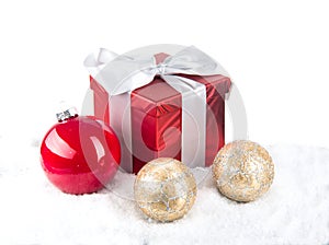 Christmas red gift with festive decorations on snow background
